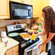 Jenna removing roasted vegetables from the oven.